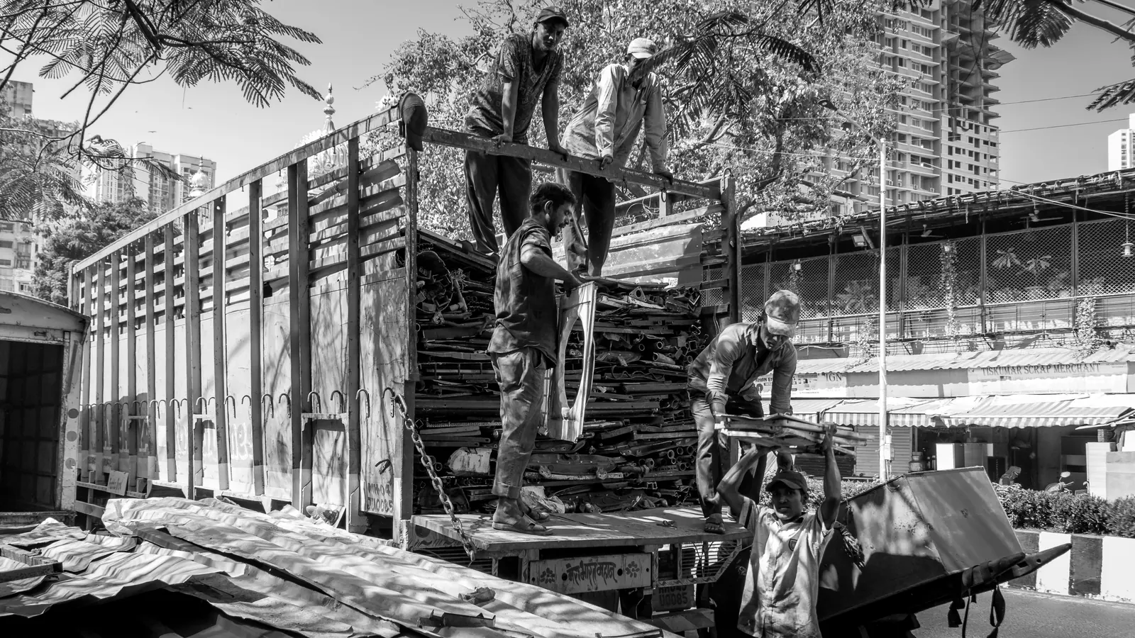 Junk removal workers loading bulky household items into a hauling truck