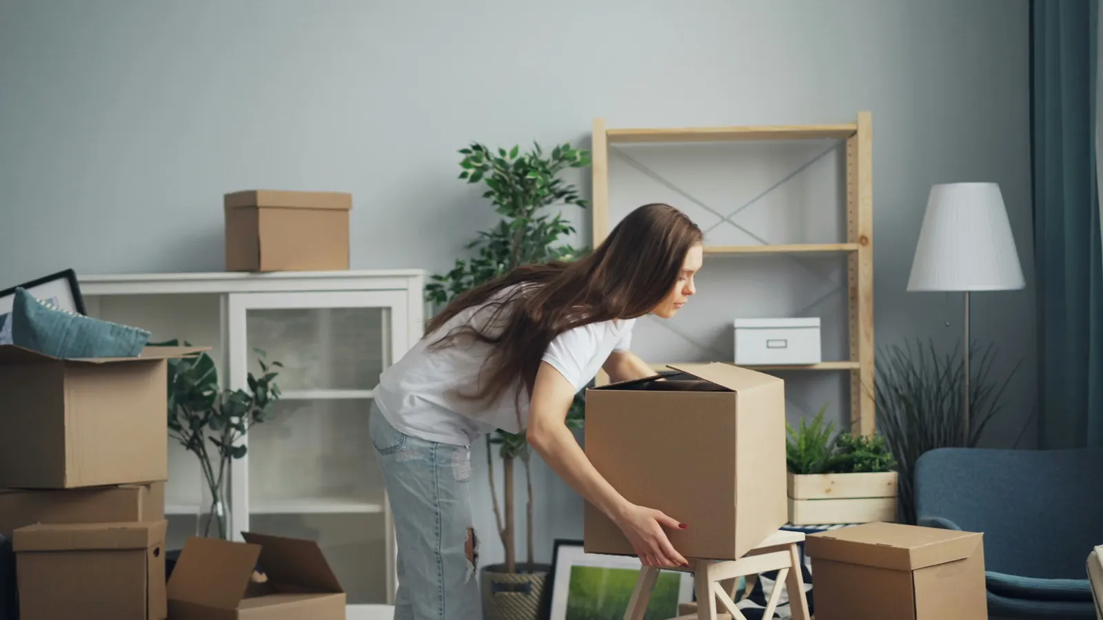 Student packing boxes during an apartment move-out cleanout in Tuscaloosa